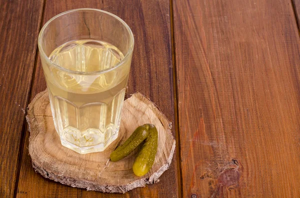 Bicchiere di succo di sottaceto, cetriolo sottaceto su legno — Foto Stock