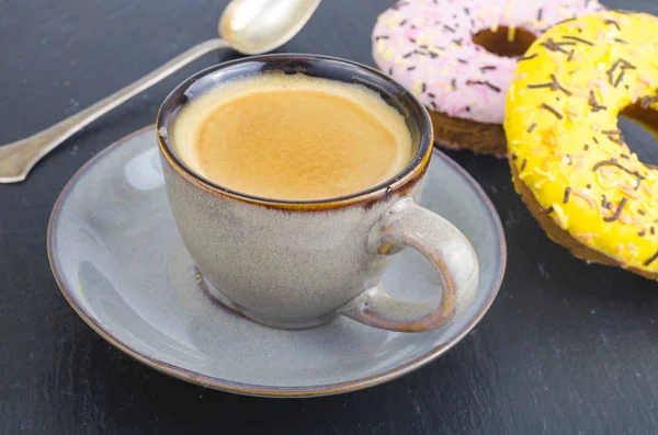 Cup of espresso with fresh pastries for breakfast on black stone background. — Stock Photo, Image