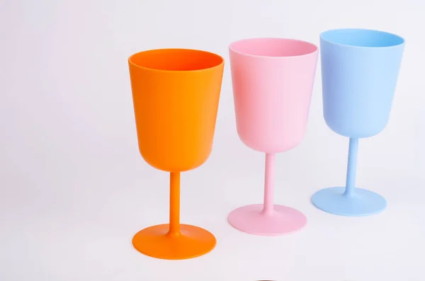 Copas de vino de plástico de color sobre fondo blanco . — Foto de Stock