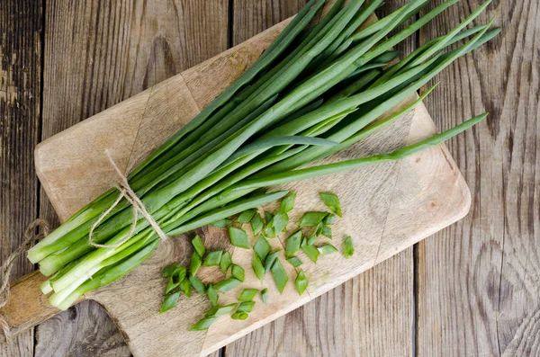 Ahşap masa üzerinde taze yeşil soğan demet.