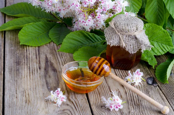 Geurige kastanje honing in pot met bloesem bloemen. — Stockfoto