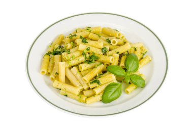 Beyaz tabakta ıspanak fesleğen pesto soslu Penne makarna.