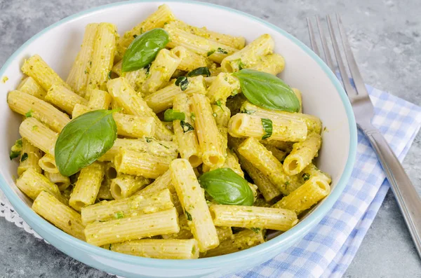 Italian pasta with pesto sauce and basil leaf