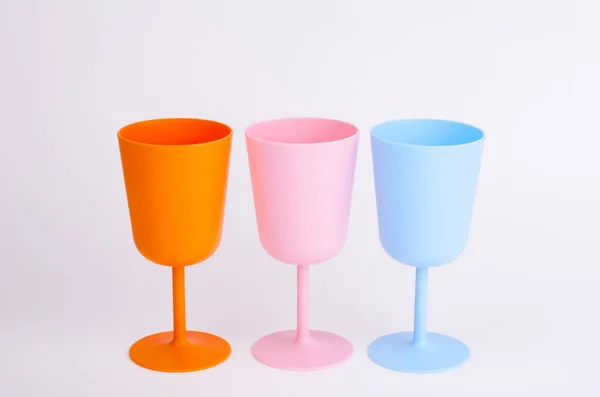 Copas de vino de plástico de color sobre fondo blanco . — Foto de Stock