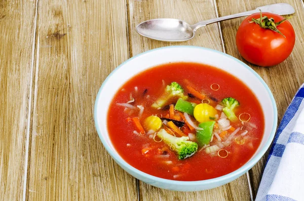 Пряный суп с помидорами на деревянном столе — стоковое фото