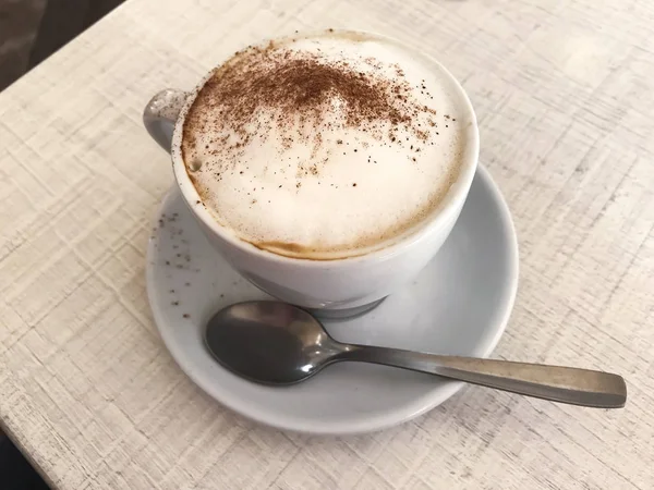 Coupe de cappuccino à la cannelle sur la table — Photo