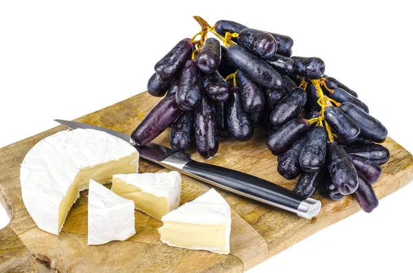 Queso Camembert con uvas negras sobre tabla de madera — Foto de Stock