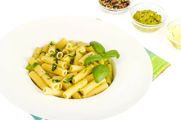 Makaron penne ze szpinakiem bazylii pesto sos na białej płycie. — Zdjęcie stockowe