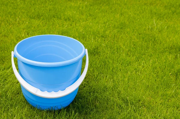 Gekleurde plastic tuin emmers op de achtergrond van groen gras — Stockfoto