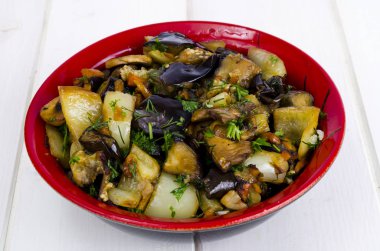 Beyaz ahşap masa üzerinde seramik kase patlıcan ile Sebze sote