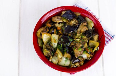 Beyaz ahşap masa üzerinde seramik kase patlıcan ile Sebze sote