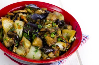 Beyaz ahşap masa üzerinde seramik kase patlıcan ile Sebze sote