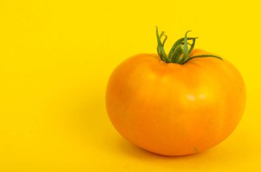 Parlak kağıt arka plan üzerinde sarı domates. Fotoğraf