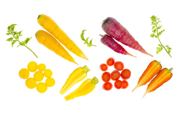 Pedaços de cenouras cruas coloridas sobre fundo branco — Fotografia de Stock