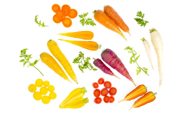 Pièces de carottes crues colorées sur fond blanc — Photo