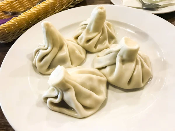 Piatti della cucina georgiana. Khinkali con carne sul piatto — Foto Stock