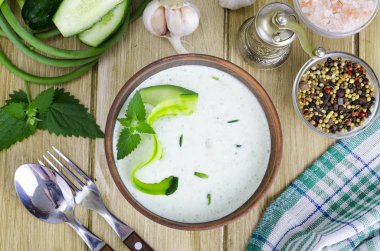 Seramik kasede ahşap masa üzerine rendelenmiş salatalık, yoğurt, zeytinyağı ve taze dereotu ile hazırlanan geleneksel yunan dip sosu veya sos tzatziki.
