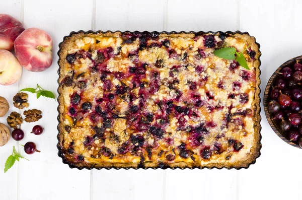 Hausgemachte Torte mit Beeren, Früchten und Walnüssen in Form auf hellem Hintergrund. — Stockfoto