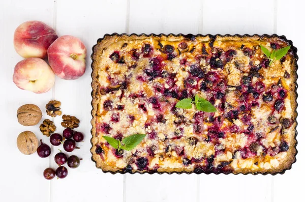 Hausgemachte Torte mit Beeren, Früchten und Walnüssen in Form auf hellem Hintergrund. — Stockfoto