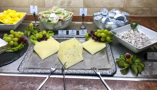 Uppsättning av olika välsmakande Skivad ost med smör, margarin, vindruvor. — Stockfoto