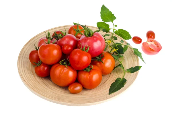 Wooden dish with different ripe tomatoes on white background. — Stock Photo, Image