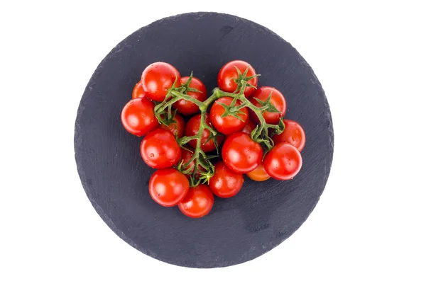 Bund roter Kirschtomaten auf schwarzem Steinteller — Stockfoto