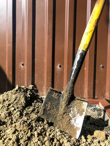 Dirty shovel in black earth, gardening job
