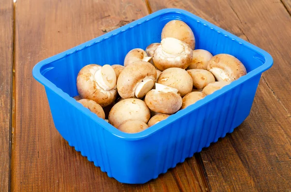 Pacote de azul com champinhons castanhos frescos . — Fotografia de Stock