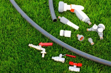 Plastik, sulama kutusu, bahçeyi sulamak için hortum, çimen. Stüdyo Fotoğrafı