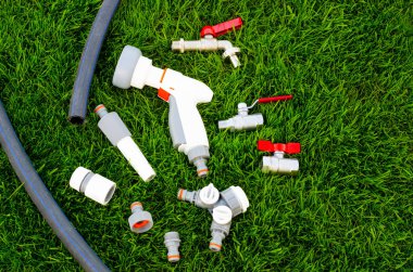 Plastik, sulama kutusu, bahçeyi sulamak için hortum, çimen. Stüdyo Fotoğrafı