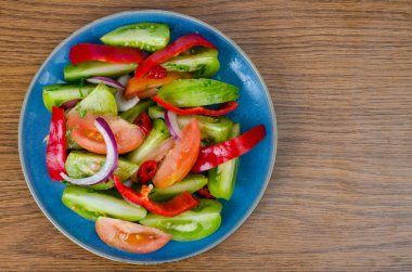 Mavi tabakta vejetaryen sebze salatası, ahşap arka plan. Stüdyo Fotoğrafı