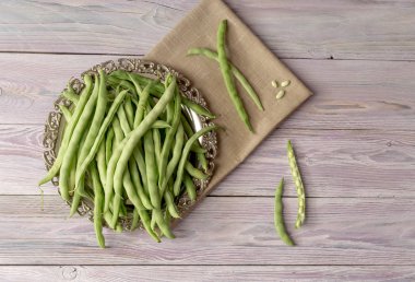 Bir tepsi yakın çekim ahşap arka plan üzerinde taze, yeşil fasulye