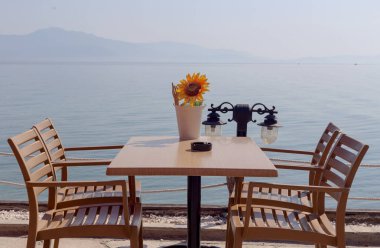 Ahşap masa ve sandalyeler gün güneşli yaz deniz arka plan üzerinde bir sokak Cafe