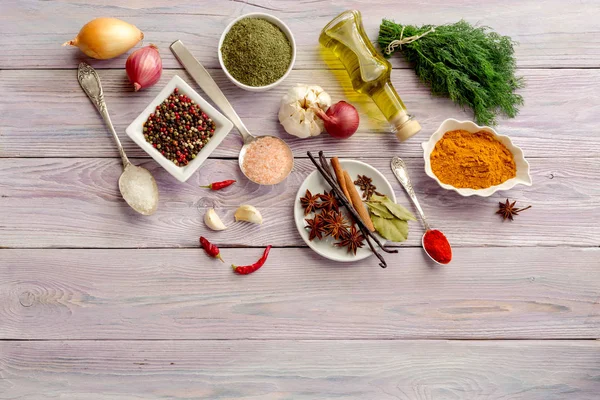 Baharatlar, zeytin yağ tabak ve kaşık ve mutfak otlar menekşe, ahşap masa yakın çekim üzerinde çeşitli.