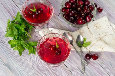 Yazlık, kiraz ve nane bir menekşe, ahşap arka plan yakın çekim üzerinde lezzetli jöle