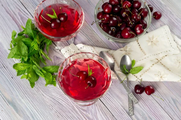 Yazlık, kiraz ve nane bir menekşe, ahşap arka plan yakın çekim üzerinde lezzetli jöle