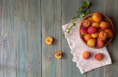 Ahşap arka plan yakın çekim üzerinde bir sepet içinde olgunlaşmış, lezzetli, sulu, yüksek kaliteli kayısı