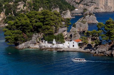 View of the Orthodox, Christian Church of the Mother of God on a small island in a sunny, summer day (resort city Parga, region of Epirus, Greece) clipart