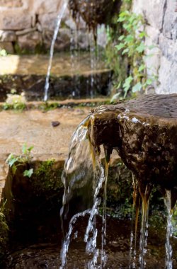 Soğuk su güneşli yaz gününde (bölge Tzoumerka, Yunanistan, dağlar Pindos Dağları ile taş kaynak yakın çekim).