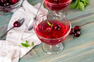 Yazlık, kiraz ve nane yeşil, ahşap arka plan yakın çekim üzerinde lezzetli jöle