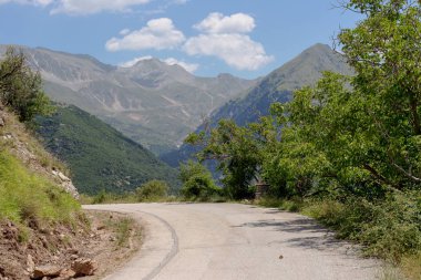 Kırsal bir yol ve dağlar görünümünü güneşli, bir yaz gününde (bölge Tzoumerka, Epirus, Yunanistan).
