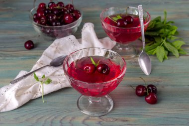 Yazlık, kiraz ve nane yeşil, ahşap arka plan yakın çekim üzerinde lezzetli jöle