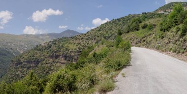Kırsal bir yol ve dağlar görünümünü güneşli, bir yaz gününde (bölge Tzoumerka, Epirus, Yunanistan).