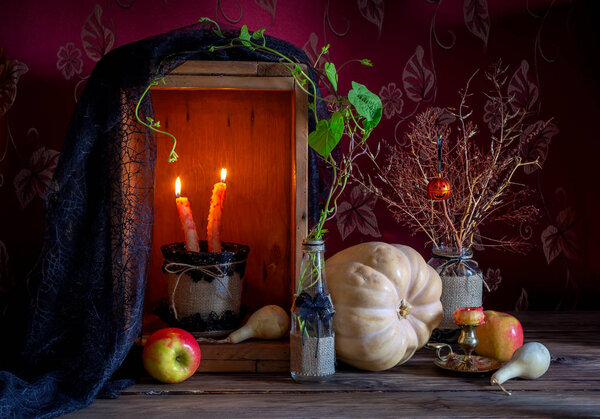 Концепция Хэллоуина. Натюрморт с тыквой, яблоками и свечой на деревянном фоне крупным планом
.