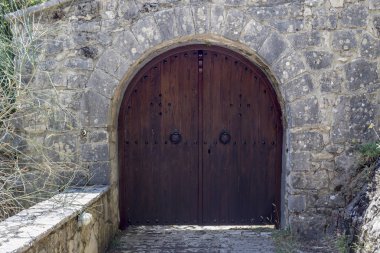 Doku, desen. Kapı ile doğal taştan yapılmış eski, bej duvar