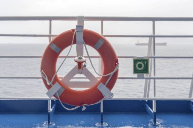 Gemide bir bulutlu gün açık denize karşı asılı ışık ile parlak lifebuoy.