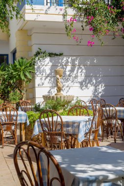 Ahşap masa masa örtüsü ve sandalye bir sokak Restoranın güneşli bir sonbahar günde (Island Crete, Yunanistan)