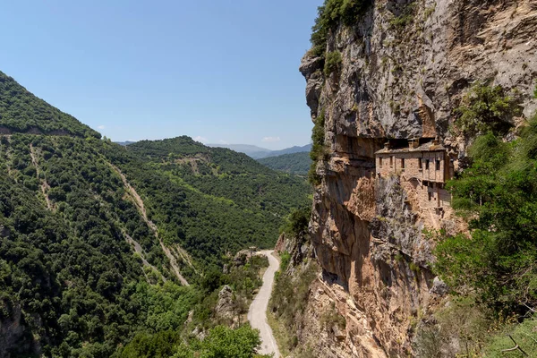 Stone, Christian, Orthodox, Holy monastery of Kipina (Tzoumerka - Katsanochoria, prefecture of Ioannina, Greece) inbuilt in the rock in the mountains on a sunny, summer day