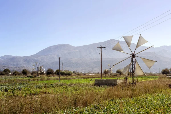 Old, historic, famous, metallic windmills who pump water out of the ground for irrigation of fields on a sunny day (Lassithi area, island Crete, Greece)