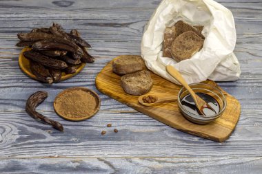 Sağlıklı diyet yiyecek. Un, kraker ve keçiboynuzu Pod ahşap arka plan yakın çekim üzerinde şurubu